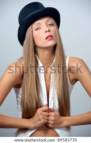 Fashion model posing in white blouse and black top hat