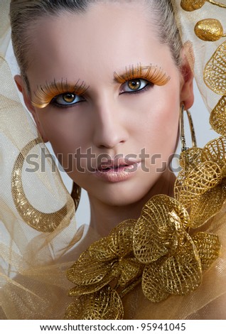 Vogue style portrait of a woman with gold makeup