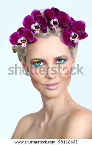 Beautiful woman with violet orchid in her hair