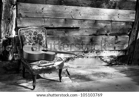 blues guitar on a old chair with wooden background horizontal black and white