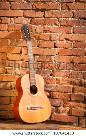 classical guitar against a brick wall vertical