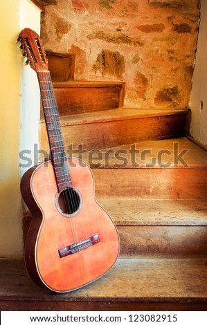 Spanish guitar on old spiral staircase vertical