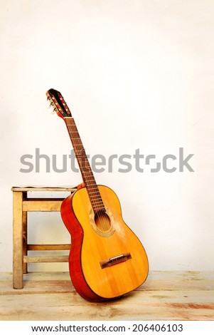 Spanish guitar propped in front of a white wall