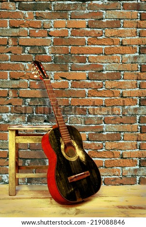black guitar with brick wall