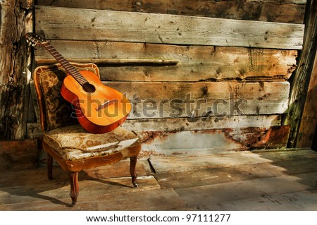 spanish guitar on a old chair with  wooden background horizontal