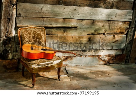 old spanish guitar on an old armchair horizontal