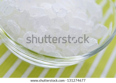White rock candy  or sugar cubes on white and green striped background
