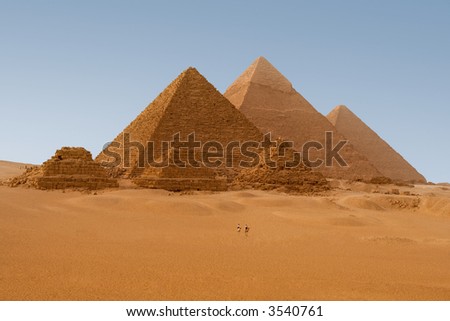 Egyptian pyramids in Giza. 2 policemen on their camels provide visual clue about how gigantic these pyramids are.