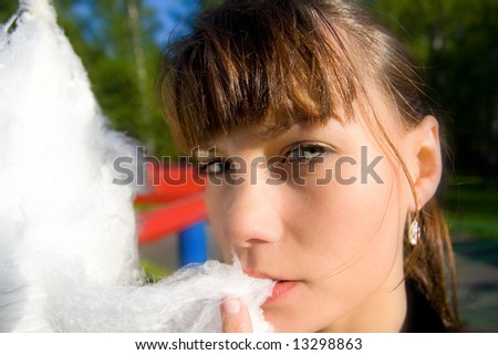 A young woman to regale with candy floss in the park