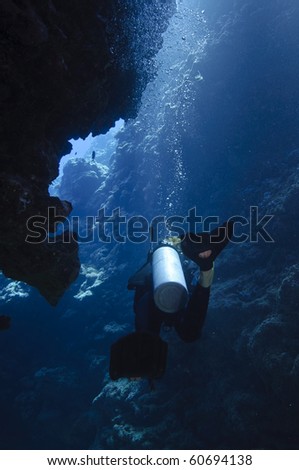 Diver exploring an underwater cave. Great barrier reef, australia