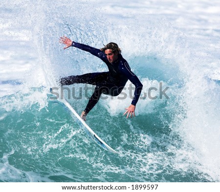 Male surfer slashes wave in cutback
