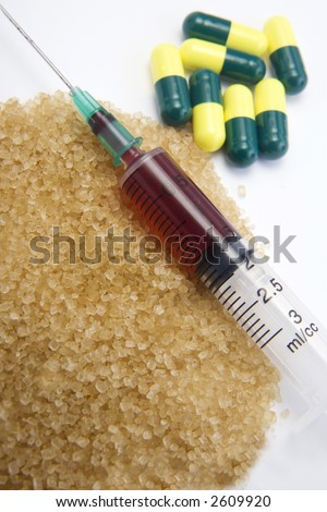 Hypodermic Syringe containing blood or red fluid with brown sugar and drug capsules