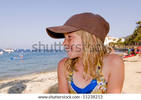 Pretty Blonde Girl in Ball Cap on a Gorgeous Beach.