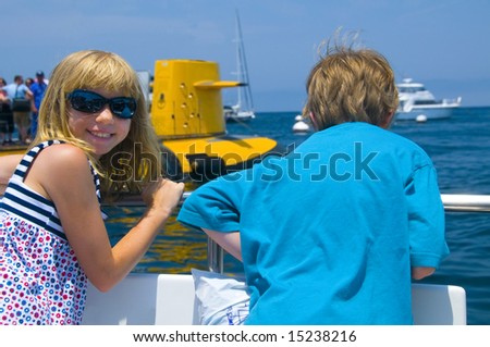 Two Kids at the rail of an Excursion Boat. (Busy B/G for a family snapshot look.)