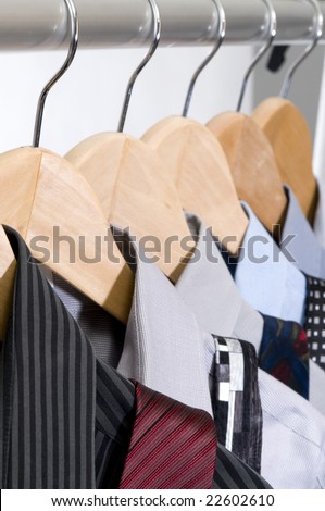 Dress shirts and ties on wooden hangers.