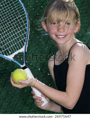 stock photo : Confident Elementary Age Girl with Tennis Ball and Racket.