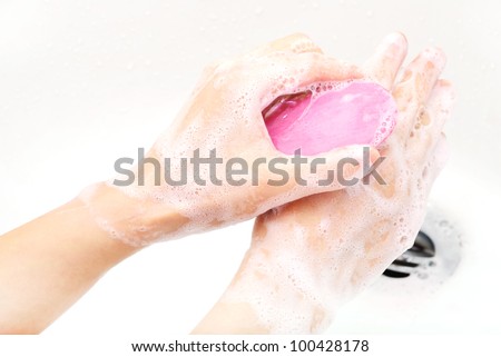 hands covered with soap being washed in the sink