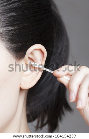 Human ear and cotton swabs close-up on white background
