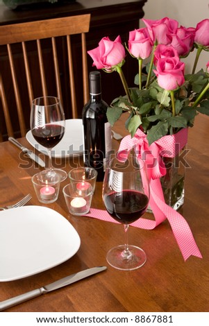 romantic dinner setting for two with wine and roses