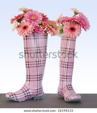 rain boots filled with pink gerber daisies