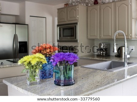 modern grey kitchen with vases of flowers on countertop - domestic life