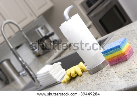 sponges, paper towels, gloves, cloths in modern kitchen for housework - narrow depth of field