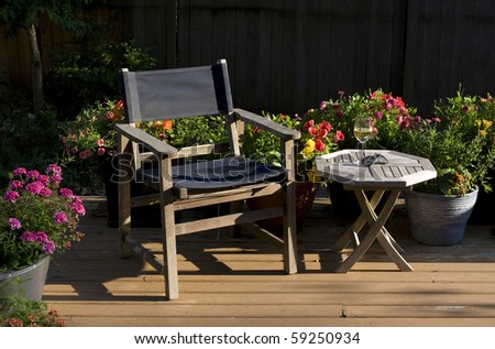 summer evening relaxation in the garden - wine, deck chair, & sunlit flowers