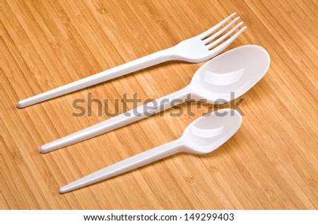 plastic disposable cutlery on a wooden background