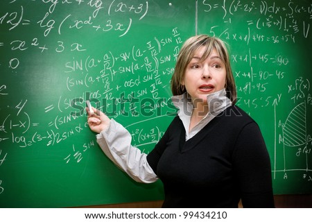Teacher pointing at blackboard teaching mathematics