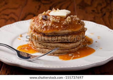 Top view of wholesome whole wheat homemade pancakes topped with walnuts and apricot sauce