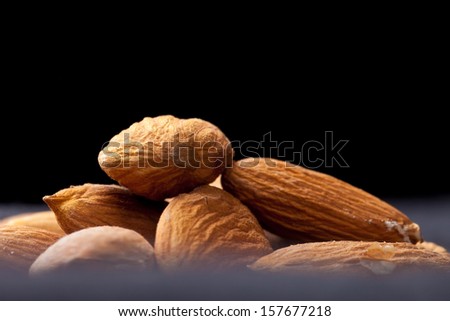 Pile of freshly harvested almonds isolated on black