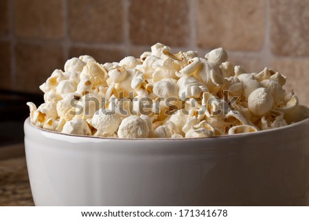 Close-up of a vintage ceramic bowl with olive oil organic popcorn on granite counter