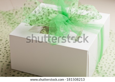 Side view of St. Patrick\'s Day gift box with Coconut Key Lime Cupcake, Pot of Gold Chocolate Caramel Cupcake, Irish Mint Chocolate Cupcake, and Green Velvet Cupcake topped with cream cheese frosting