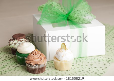 St. Patrick\'s Day gift box with Coconut Key Lime Cupcake, Pot of Gold Chocolate Caramel Cupcake, Irish Mint Chocolate Cupcake, and Green Velvet Cupcake topped with cream cheese frosting