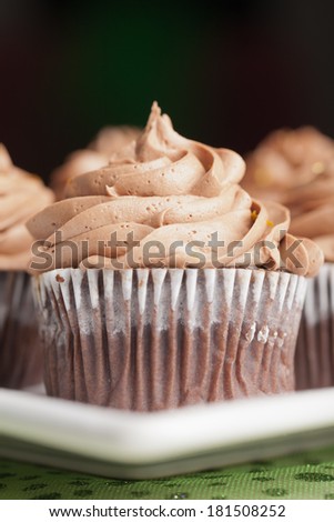 Close-up of chocolate Pot of Gold cupcakes - chocolate cake with a rich salted caramel center topped with chocolate buttercream and edible gold stars
