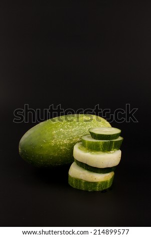 Pickling cucumber with various varieties of cucumber slices stacked on a black background