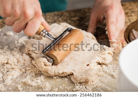 Man making pie crust from scratch - rolling out dough