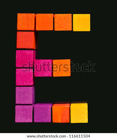 Bright colored letter of wooden blocks on a black background