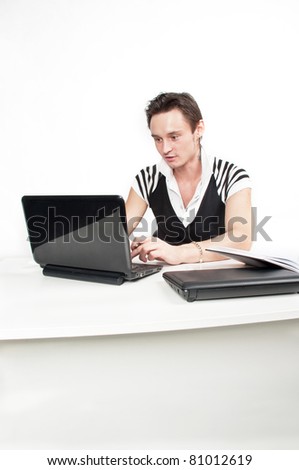 handsome young caucasian businessman with a pair laptops sitting at a table and work-flow in the office,guy at work in the office of the director,the manager works at the compute,isolated over white