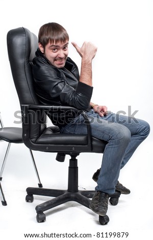 a handsome young man bad guy Caucasian sitting in a leather jacket to a leather chair and shows everything is fine, isolated over white, cool smile