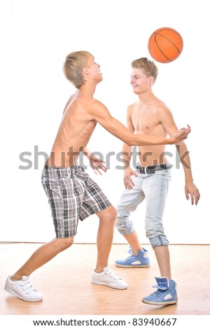 Two young guys play basketball, isolated over white