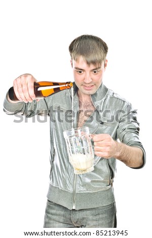 young handsome guy pours beer into the cup, isolated over white