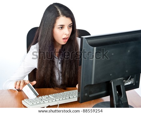 a beautiful young girl sits and works at the computer, surprise, isolated over white