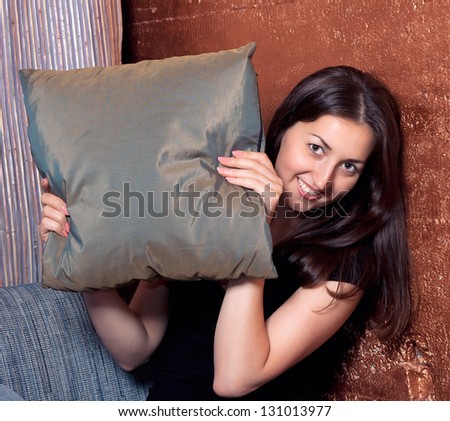 Smiling brunette girl covered pillow
