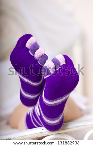 Female legs in purple socks with individual toes