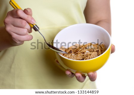 Healthy breakfast - cereal in the yellow bowl in female hands