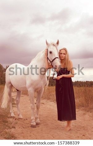 beautiful young woman with a  horse in the forest