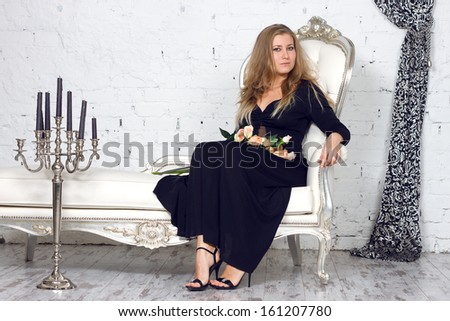 Beautiful blonde woman in dress in luxury interior.