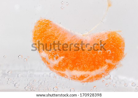 Orange (mandarin) falling in water with air bubbles