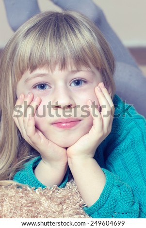 Young beautiful girl in dress laying on carpet